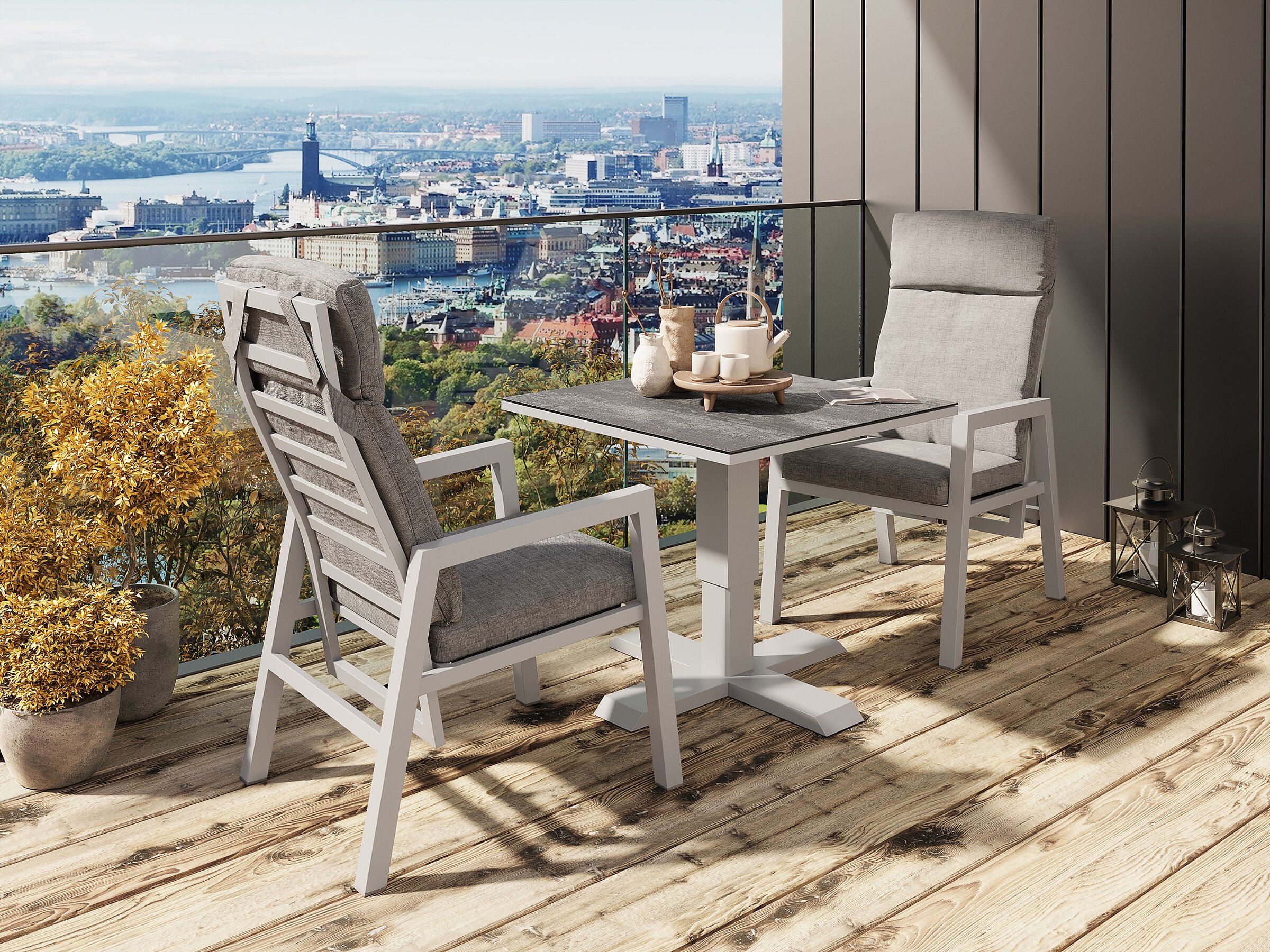 Product visualisation of the Jamaica white outdoor furniture set featuring two armchairs and an adjustable-height table on a balcony with a city view